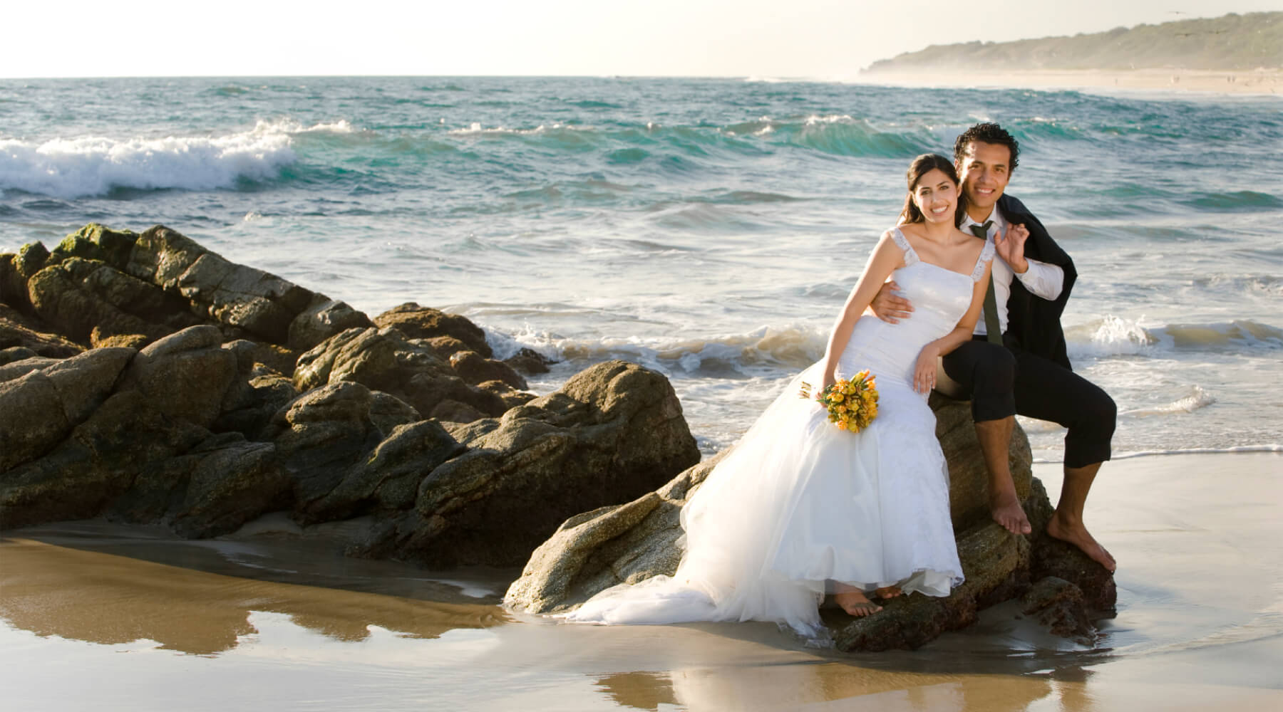 Wedding couple sitting on the beach